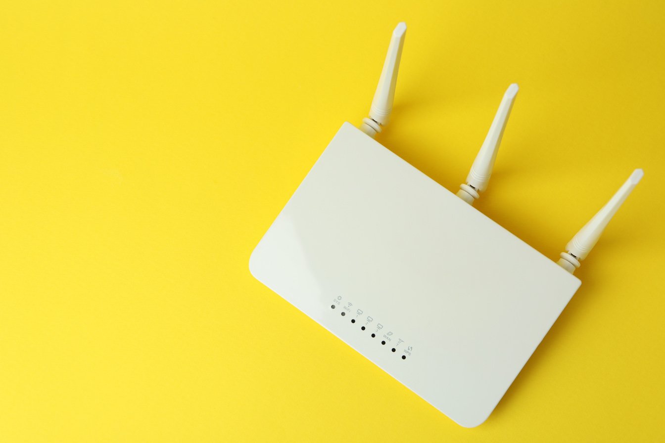 Wi-Fi Router with External Antennas on Yellow Background